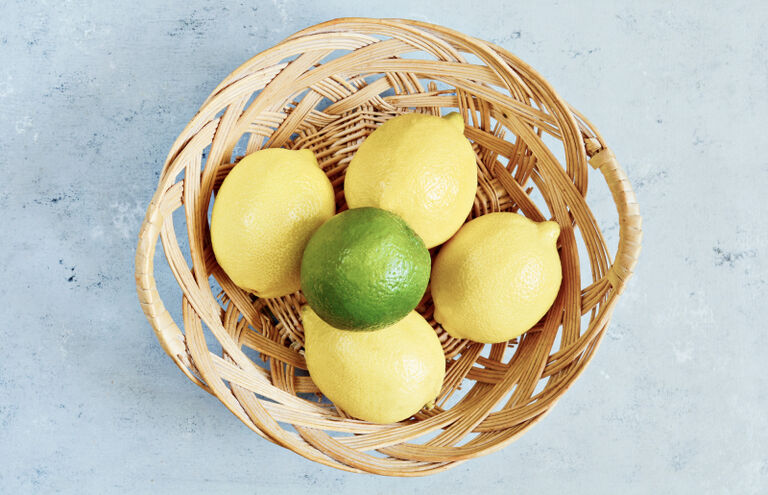 Foto eines Korbs mit Zitronen und einer Limette